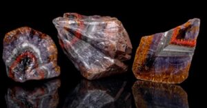 Quartz crystal The polished crystal has a golden band in the outer purple zone formed by numerous V-shaped clusters of goethite inclusions.