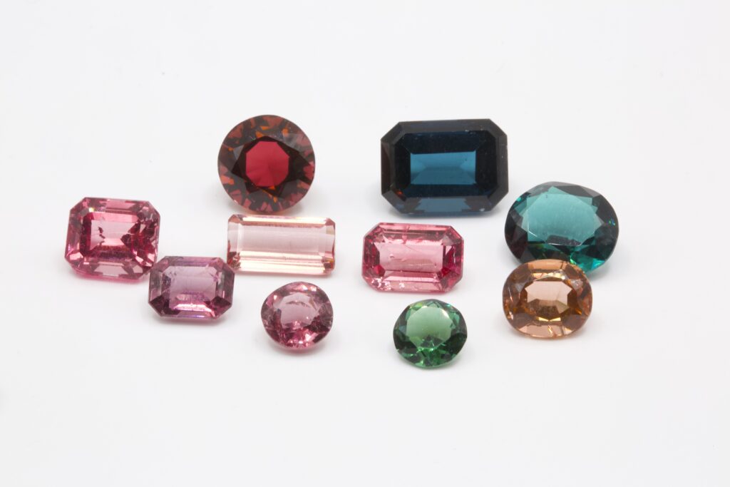 Main image: A group of cut and polished tourmaline gemstones in a range of colours, photographed by Gabriel Kleinberg.
