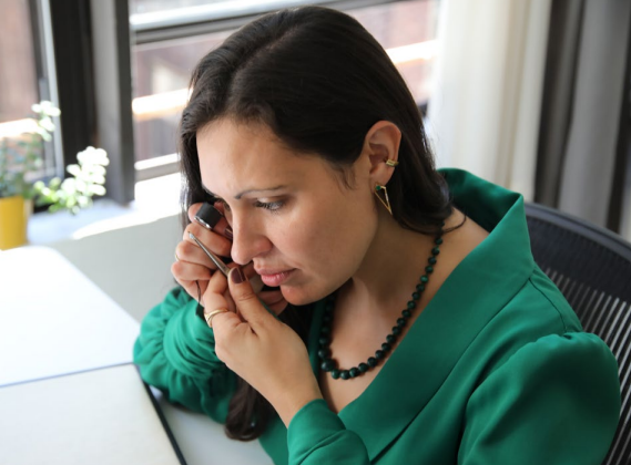 gemmologist using a 10x loupe to study a gem